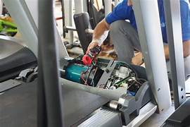 A technician performing a professional treadmill repair service on site.